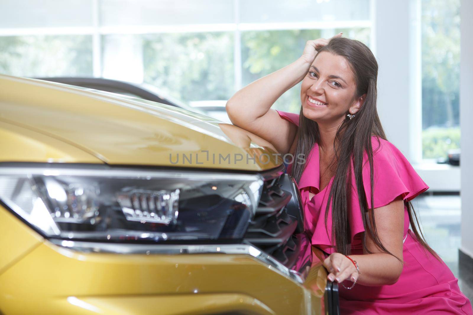 Charming plus size woman smiling to camera posing with her new automobile, copy space
