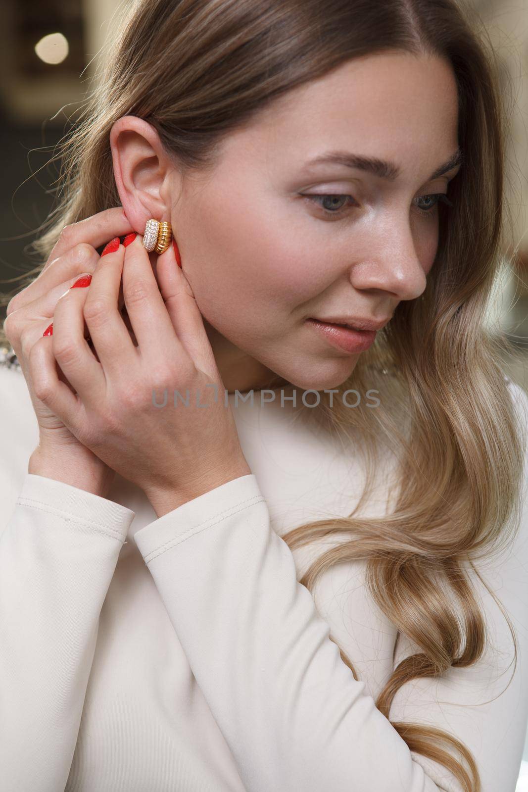 Vertical close up of a beautiful woman trying on diamond earrings