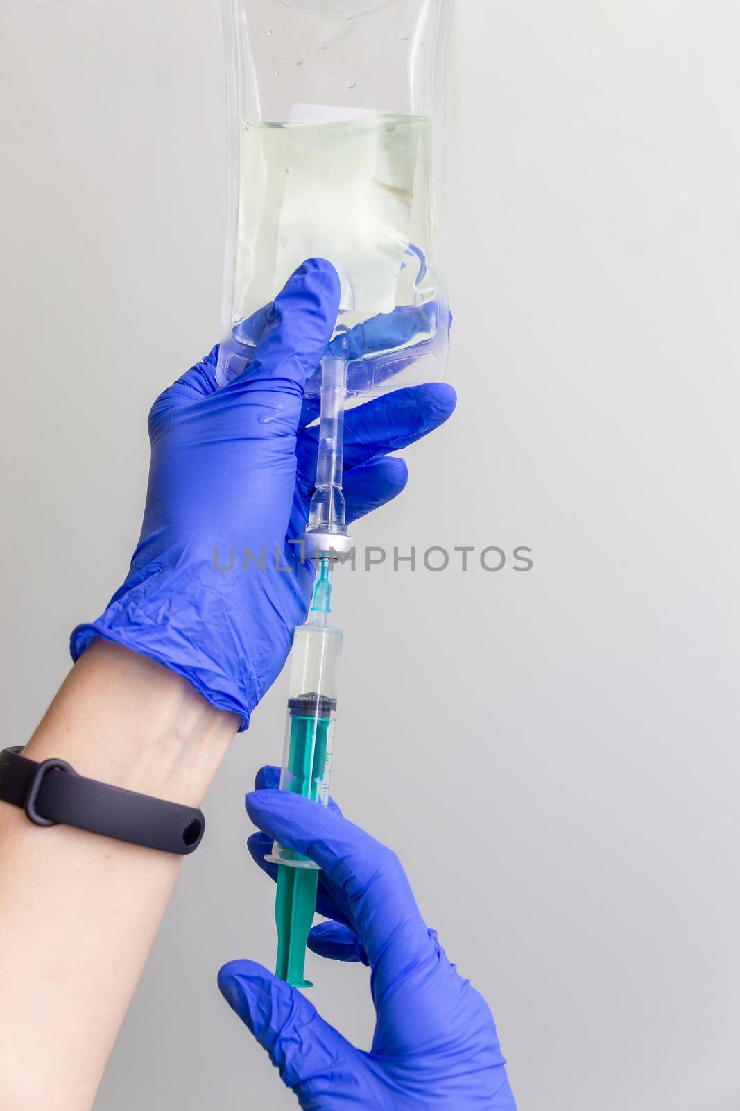 A female doctor or nurse in rubber gloves prepares the injection. Saline solution of sodium chloride. Isotonic solution.