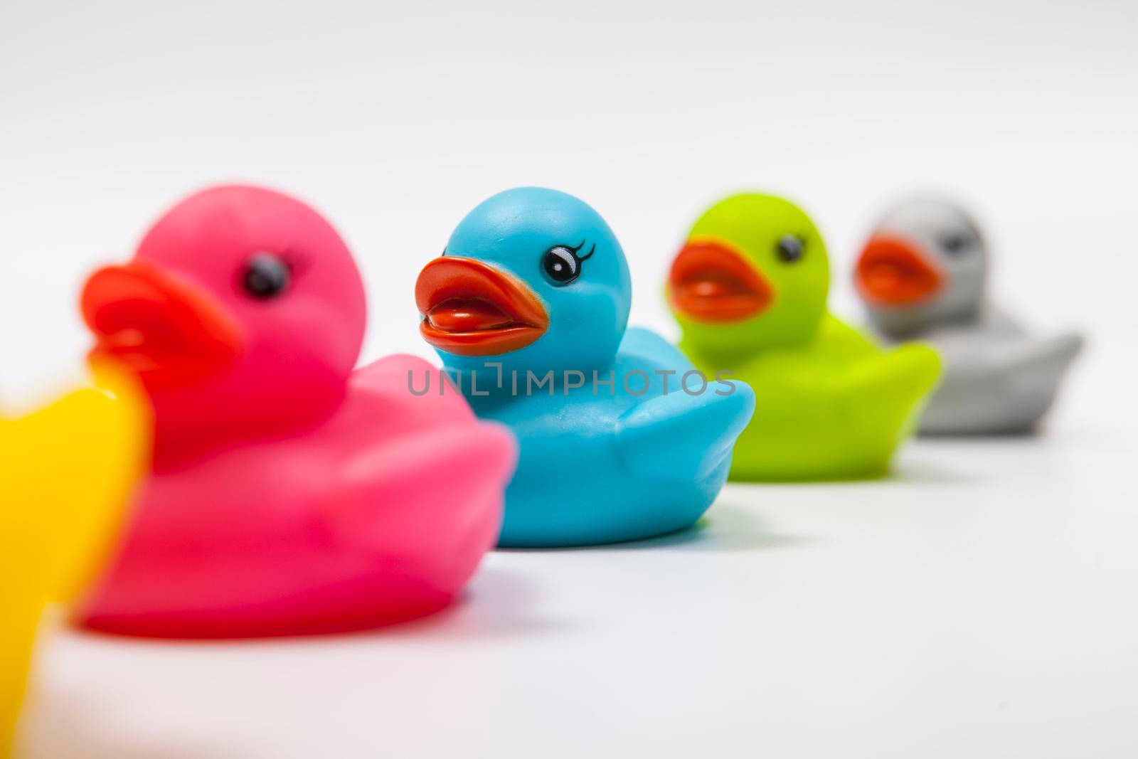 Cute blue rubber duck in a row of colorful rubber ducklings