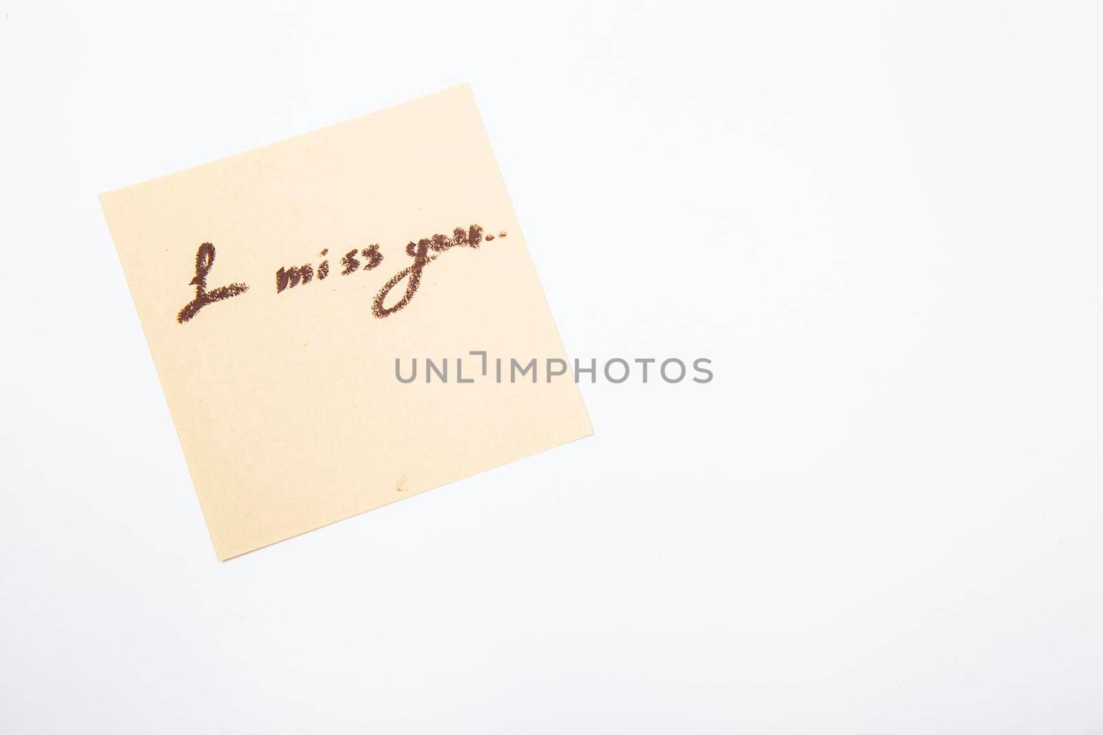 I miss you handwritten on yellow memo paper