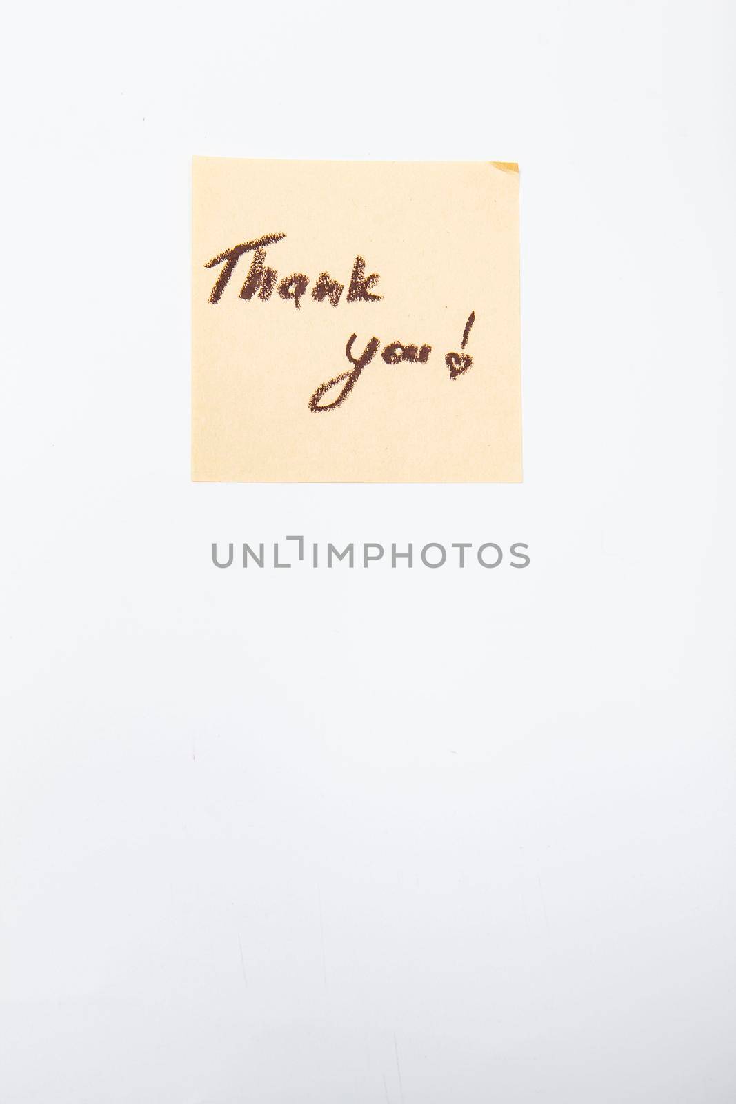 Vertical shot of a thank you note handwritten on yellow sticky paper