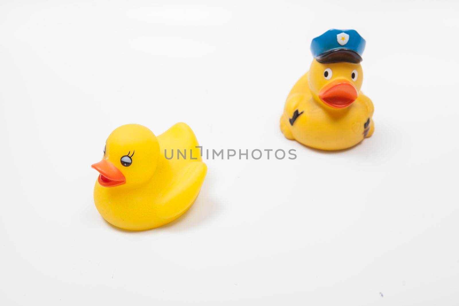 Rubber duck policeman chasing rubber duck criminal. Law enforcement concept