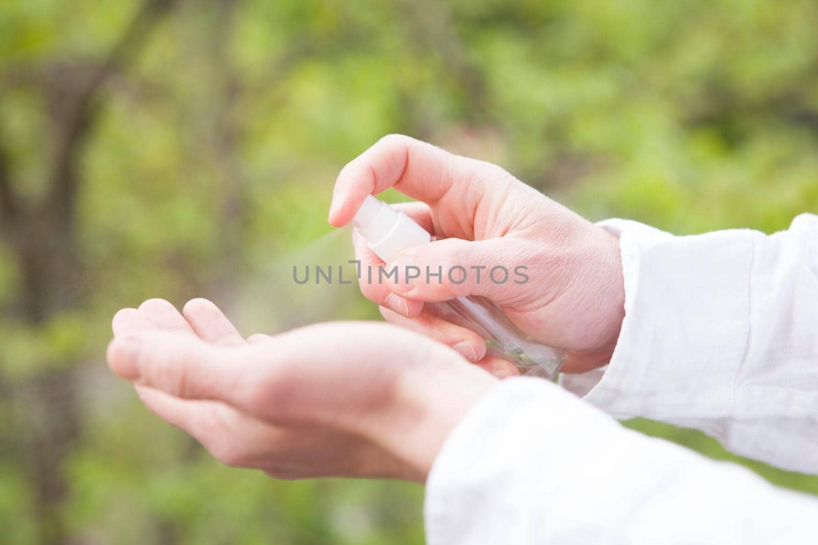 Cropped shot of a man using alcohol based hand sanitizer. Man disinfecting his hands outdoors