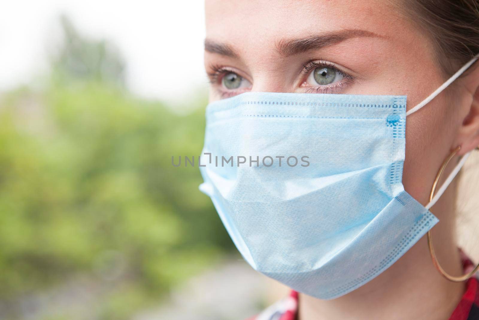 Close up of a woman looking away, wearing face protective mask on a walk outdoors