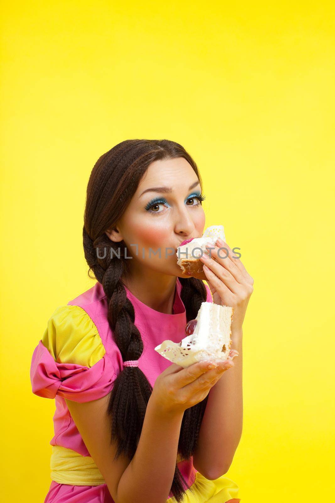 Happy girl take two cake - pin-up doll costume on yellow background