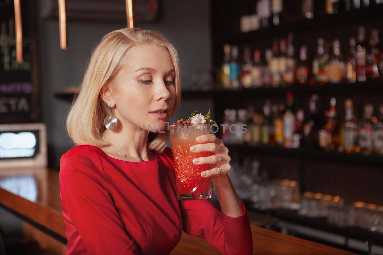 Gorgeous woman enjoying delicious cocktail at the bar, copy space