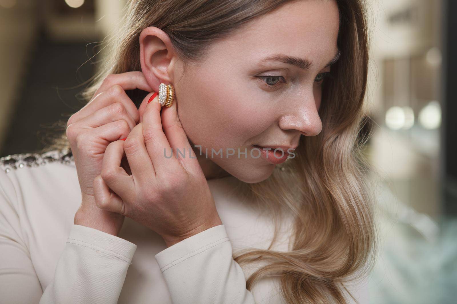 Close up of an attractive woman putting on diamond earrings