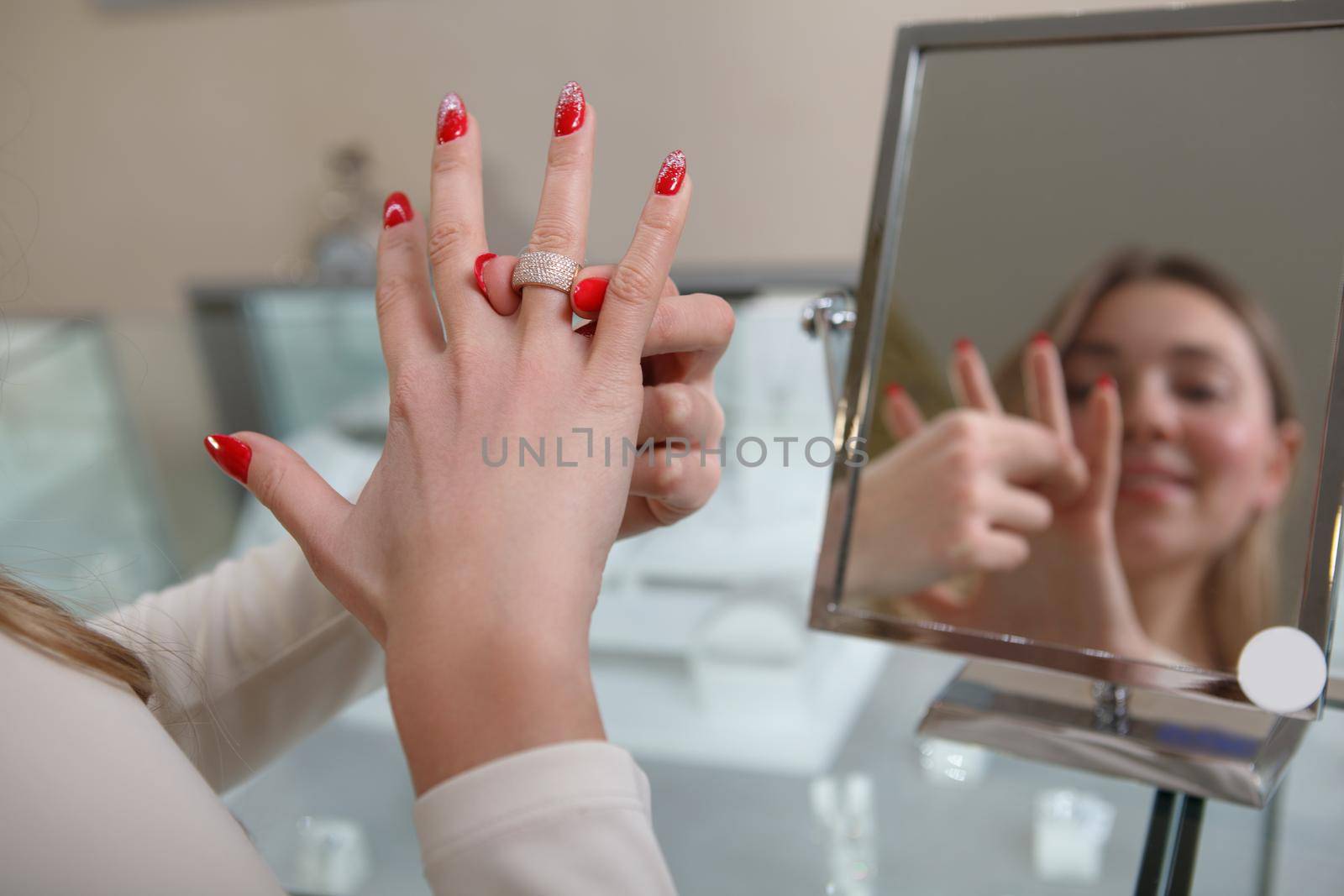Cropped shot of a woman putting on diamond ring at jewelry store