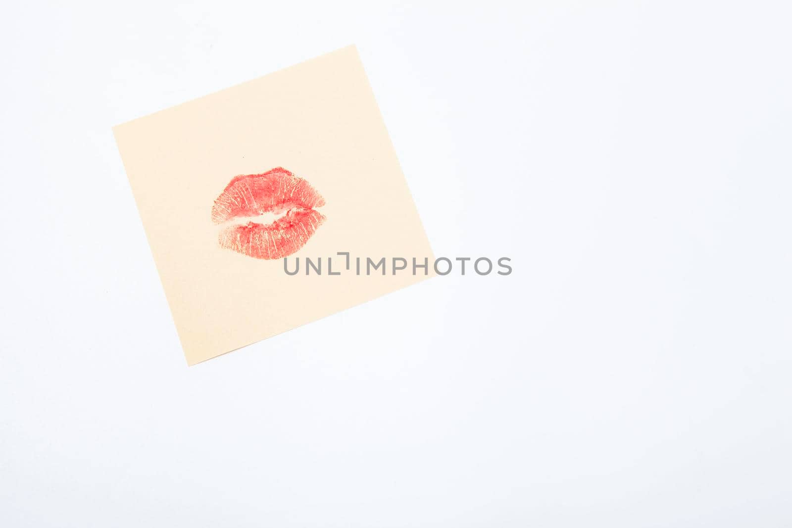 Red lipstick kiss on yellow memo paper piece