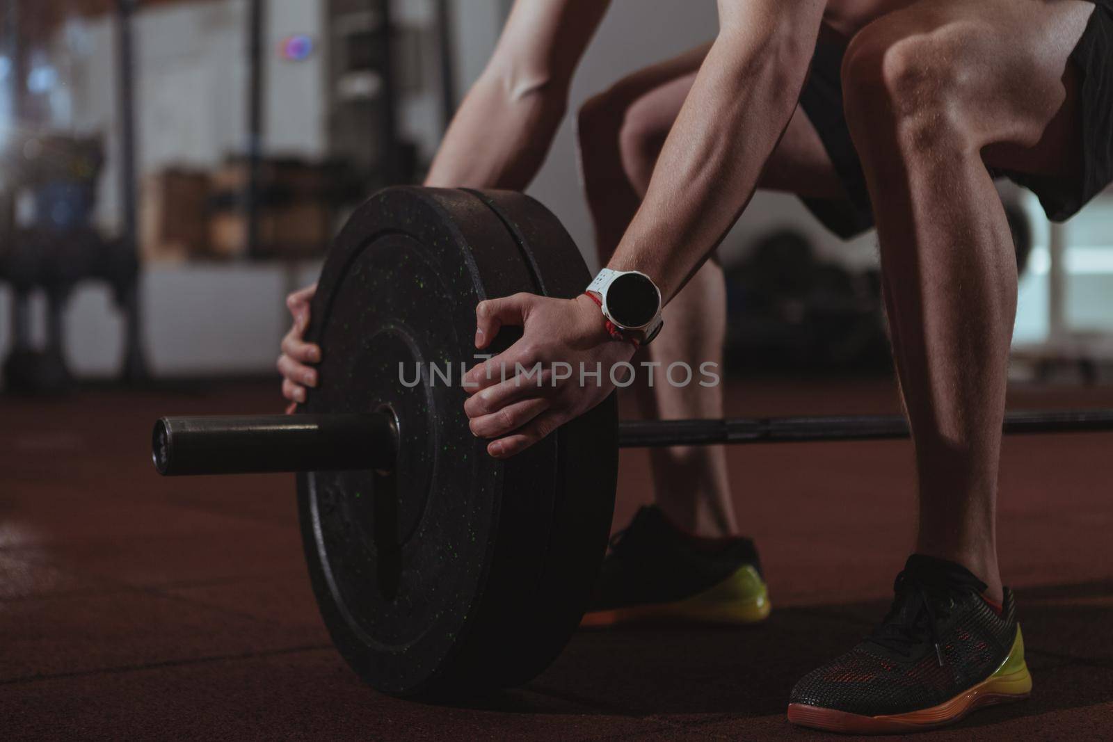 Strong male crossfit athlete exercising with heavy barbell by MAD_Production