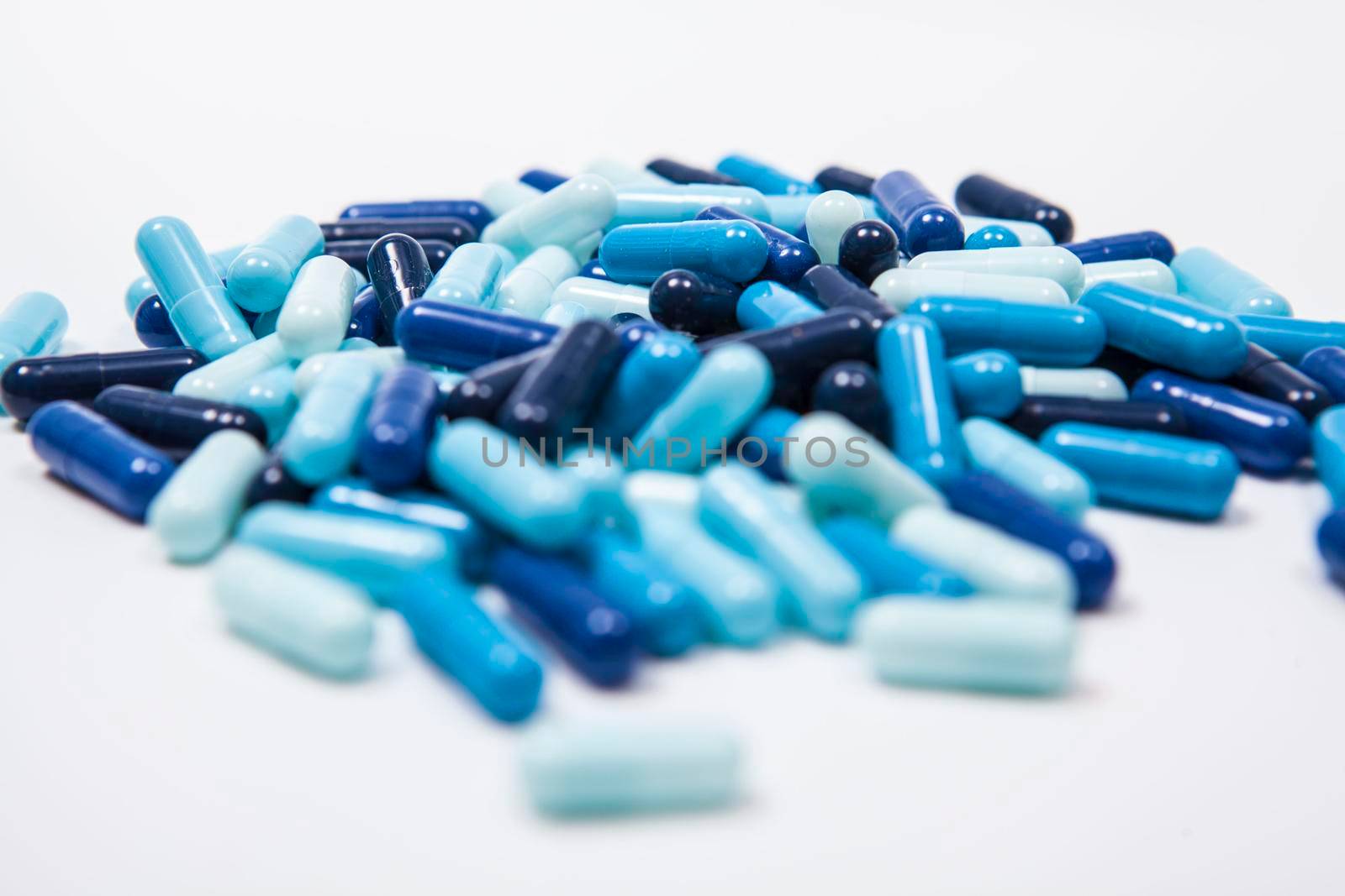 Many capsules pills on white background by MAD_Production