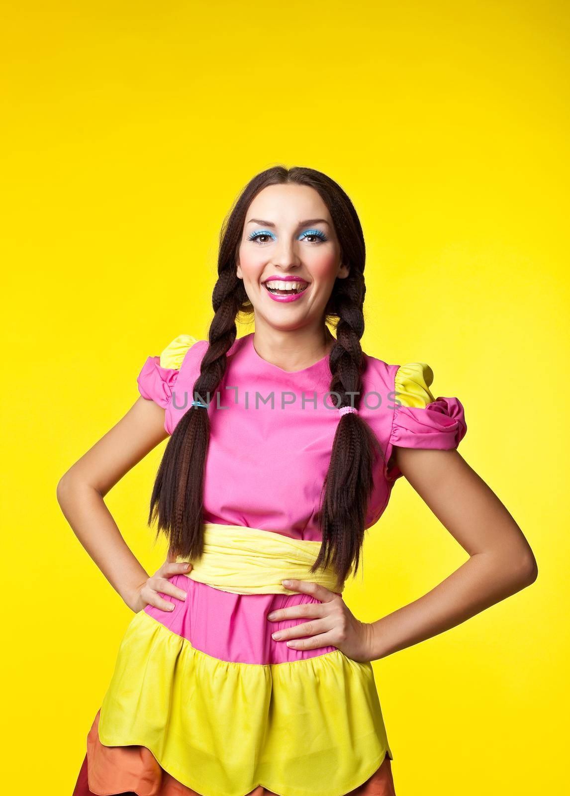 Young cute girl in doll costume and pin-up make-up smile on yellow background