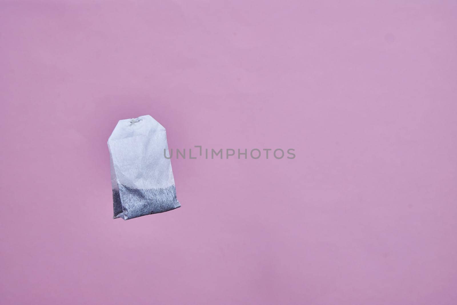 a tea bag spinning on a pink background by vadiar