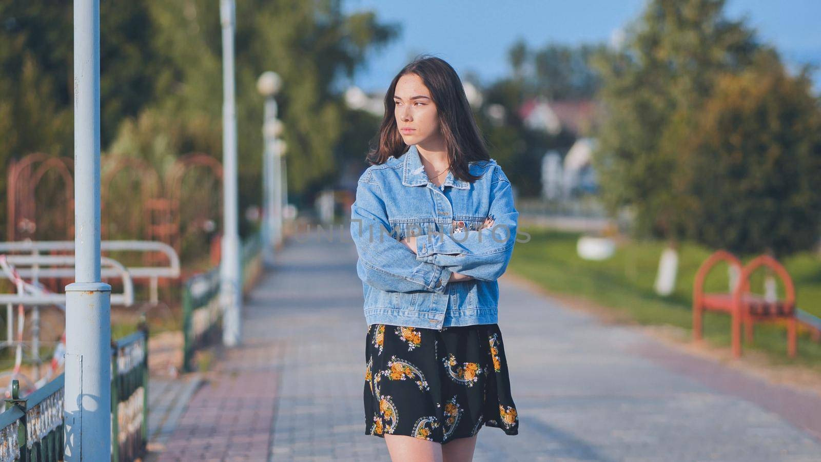 A lonely girl walks along the city's promenade