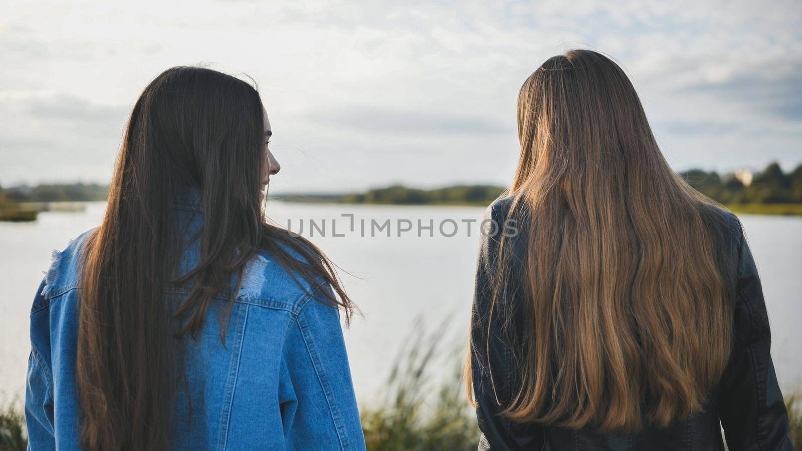 Two friendly friends sit and cuddle by the lake