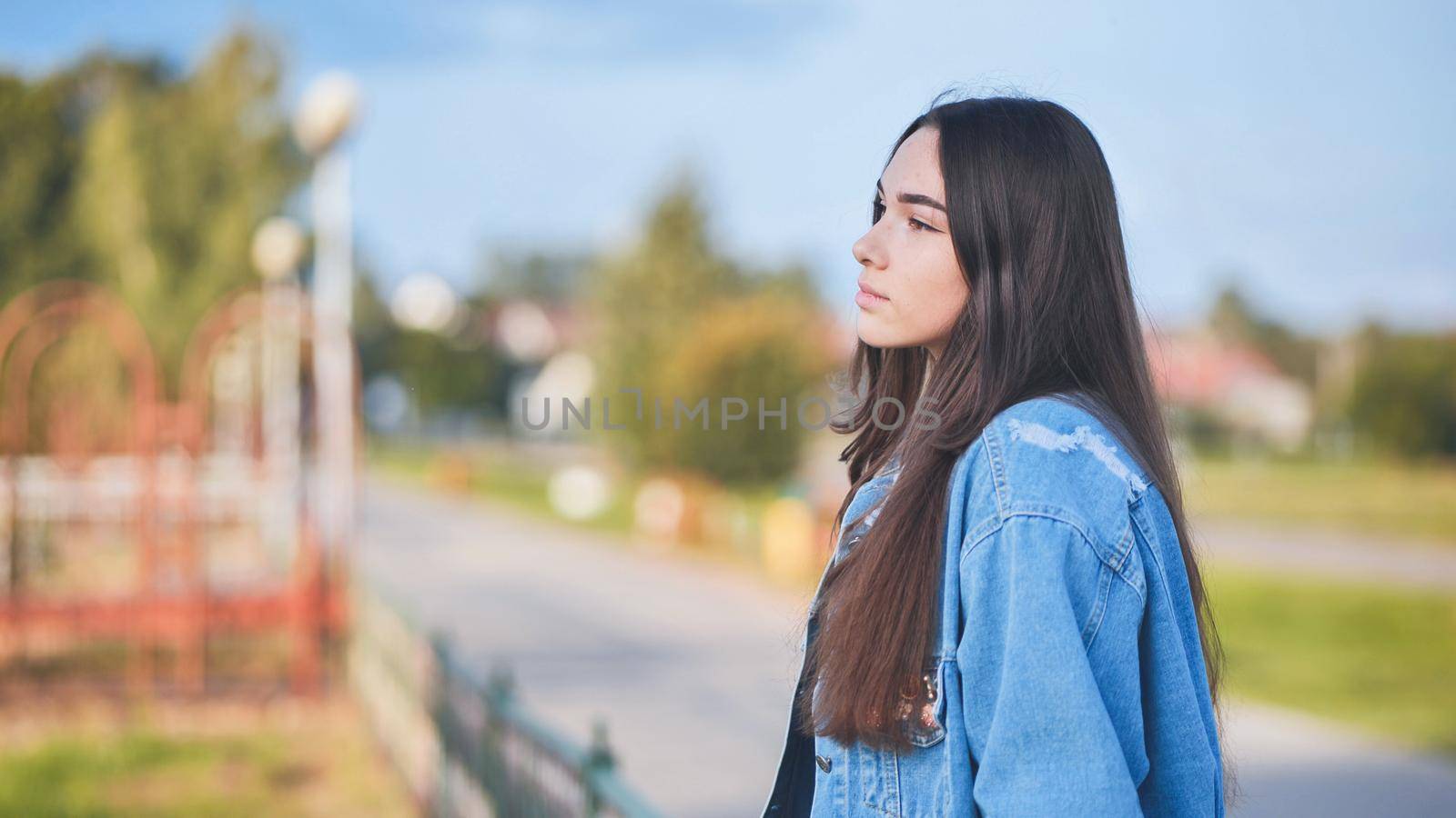 Portrait of a lonely girl by a lake