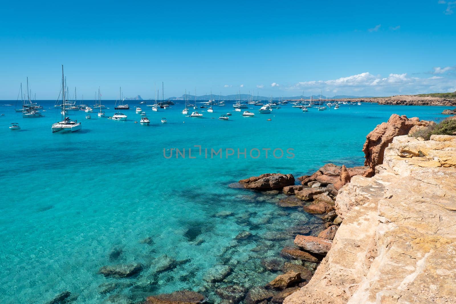 Panoramic view of Cala Saona with sailboats anchored in the Mediterranean Sea