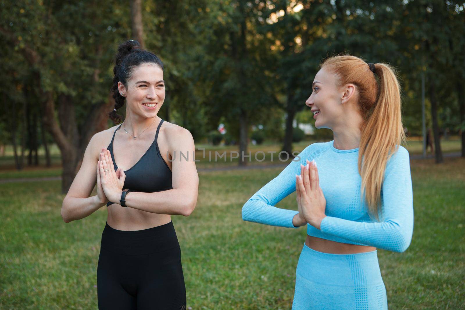 Women doing yoga outdoors at the park by MAD_Production