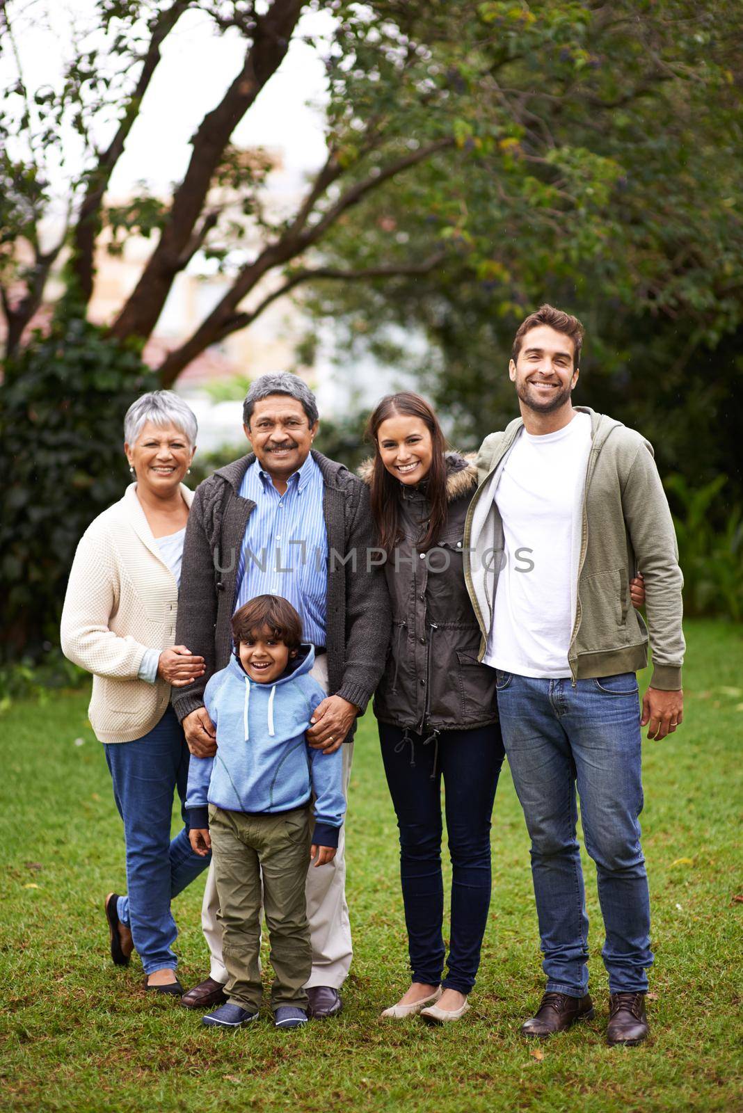 Special family bonds. Full length portrait of a multi-generational family standing together outside. by YuriArcurs
