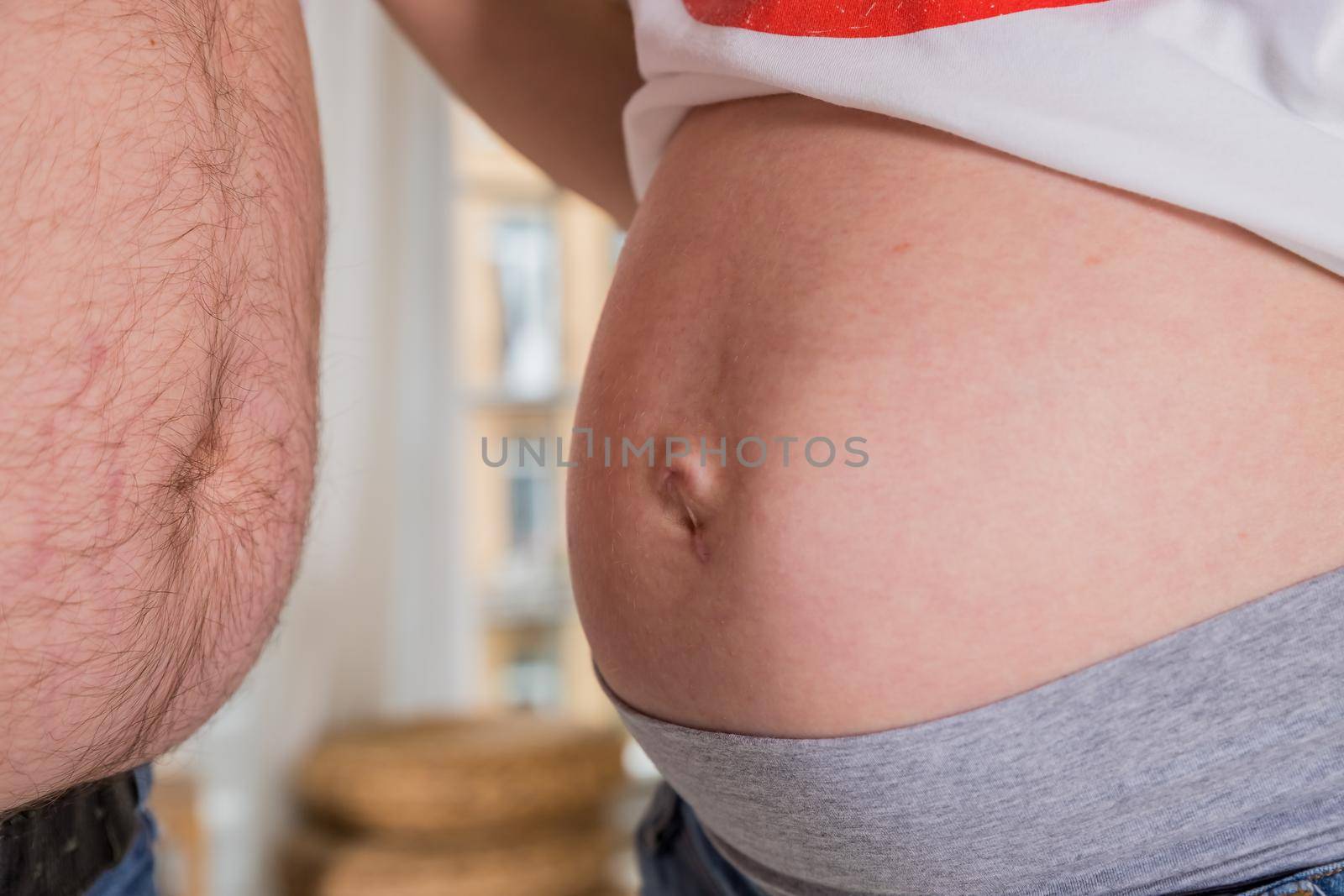 Belly of pregnant woman. A pregnant woman cannot close her jeans. The concept of clothing becomes small due to the growth of the abdomen
