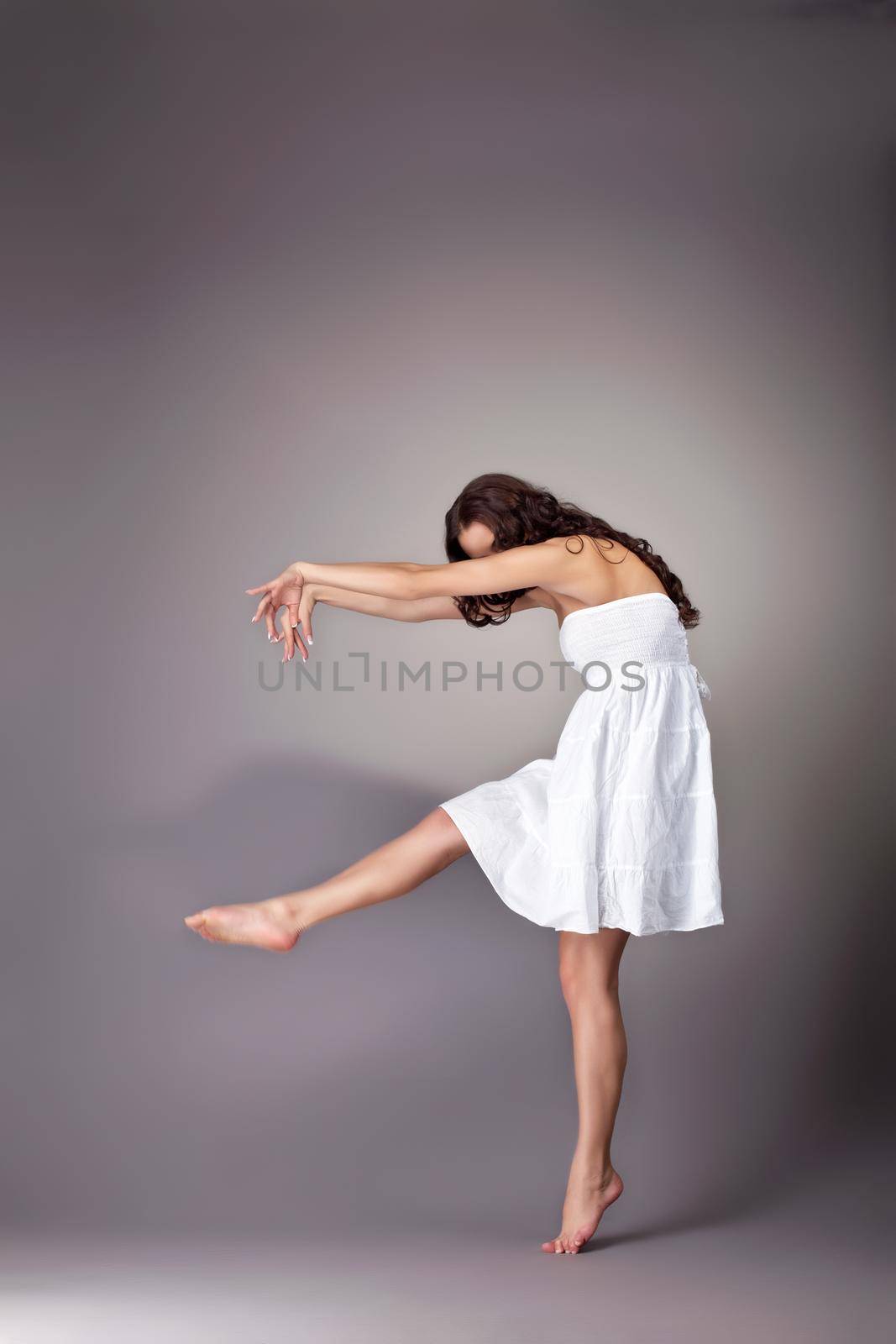 Beautiful young woman in white dress dance with shadow