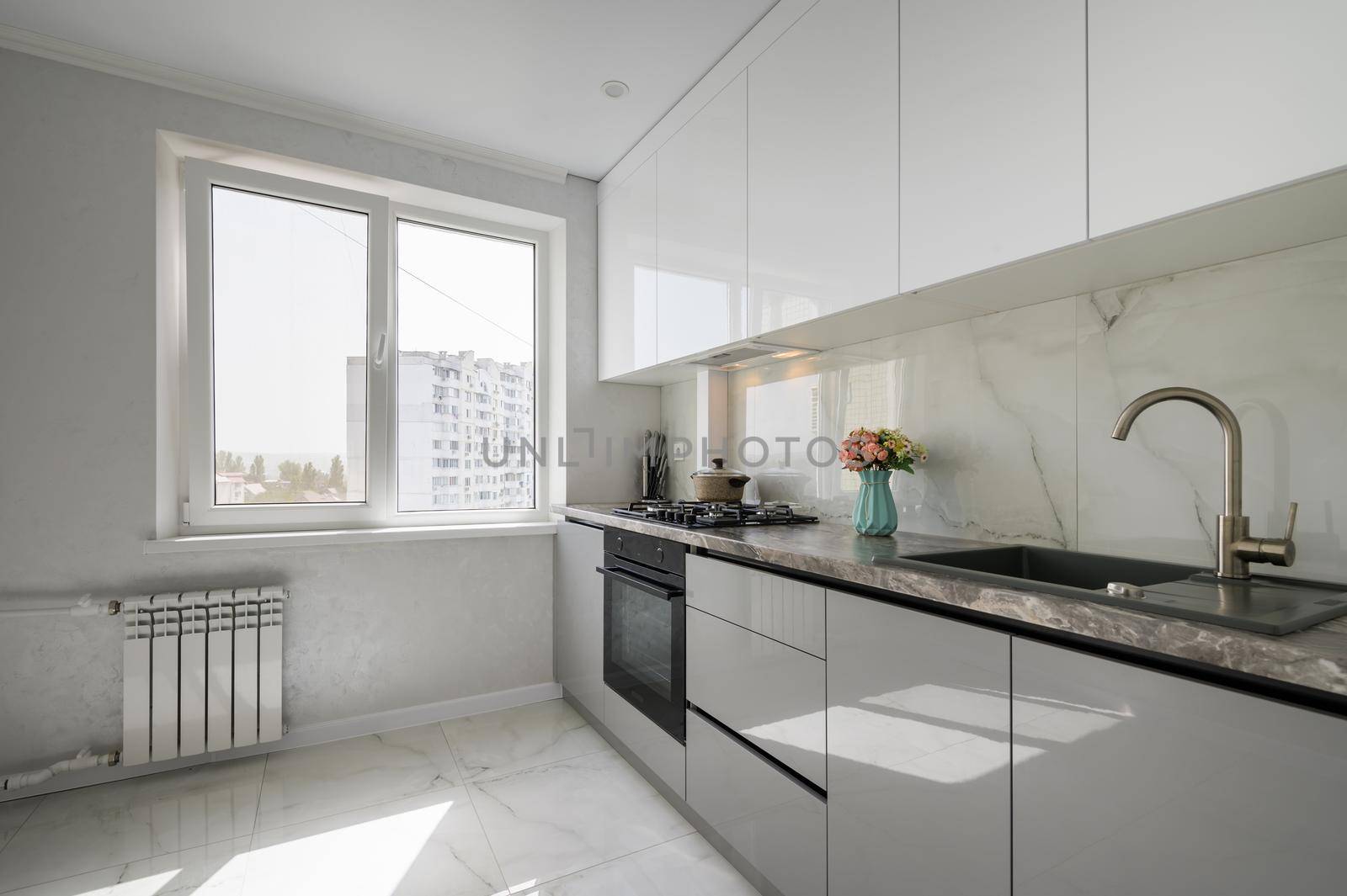 Interior of white and grey small modern domestic kitchen furniture