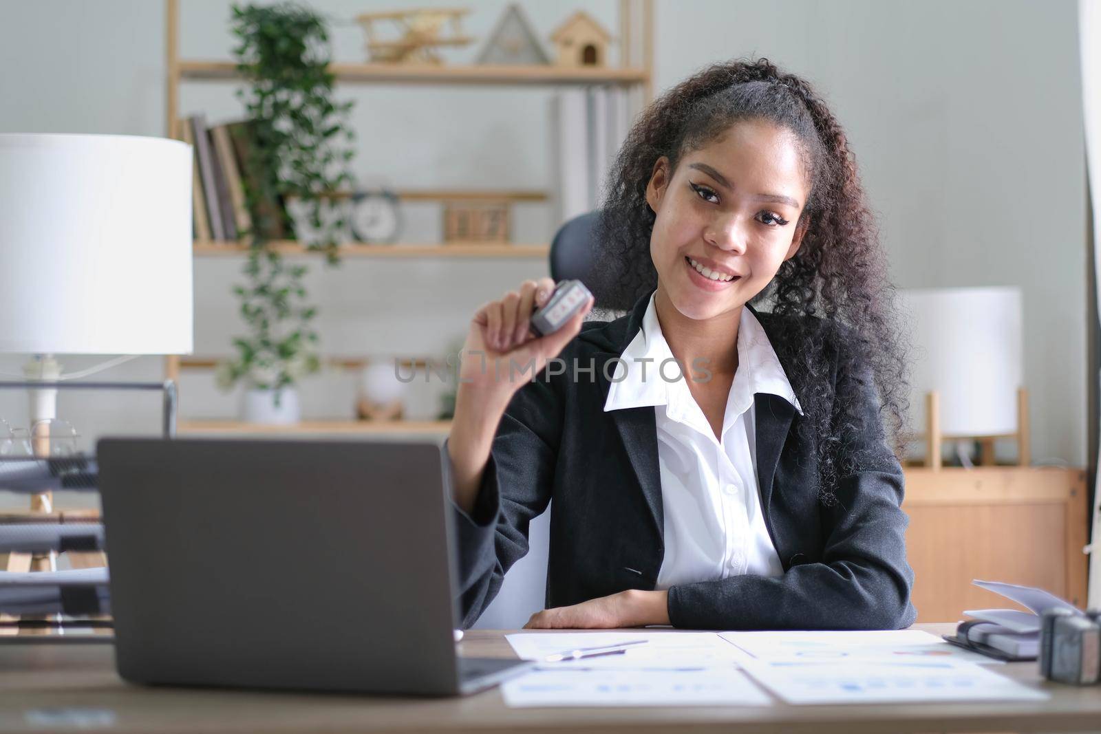 Creative young african american woman working on laptop in her studio,Doing accounting analysis report real estate investment data, Financial and tax systems concept. by wichayada