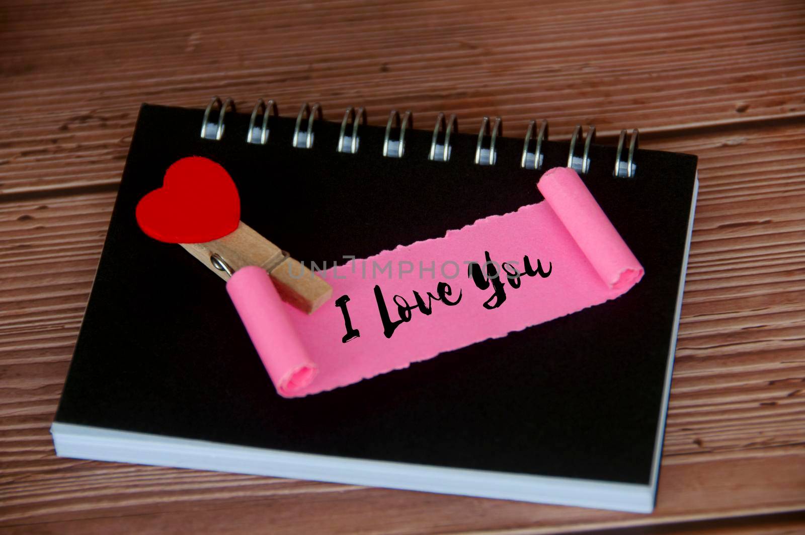 I love you text on torn pink paper. Romance and relationship concept.