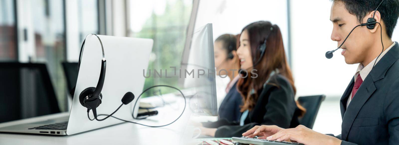 Business people wearing headset working in office in widen view by biancoblue