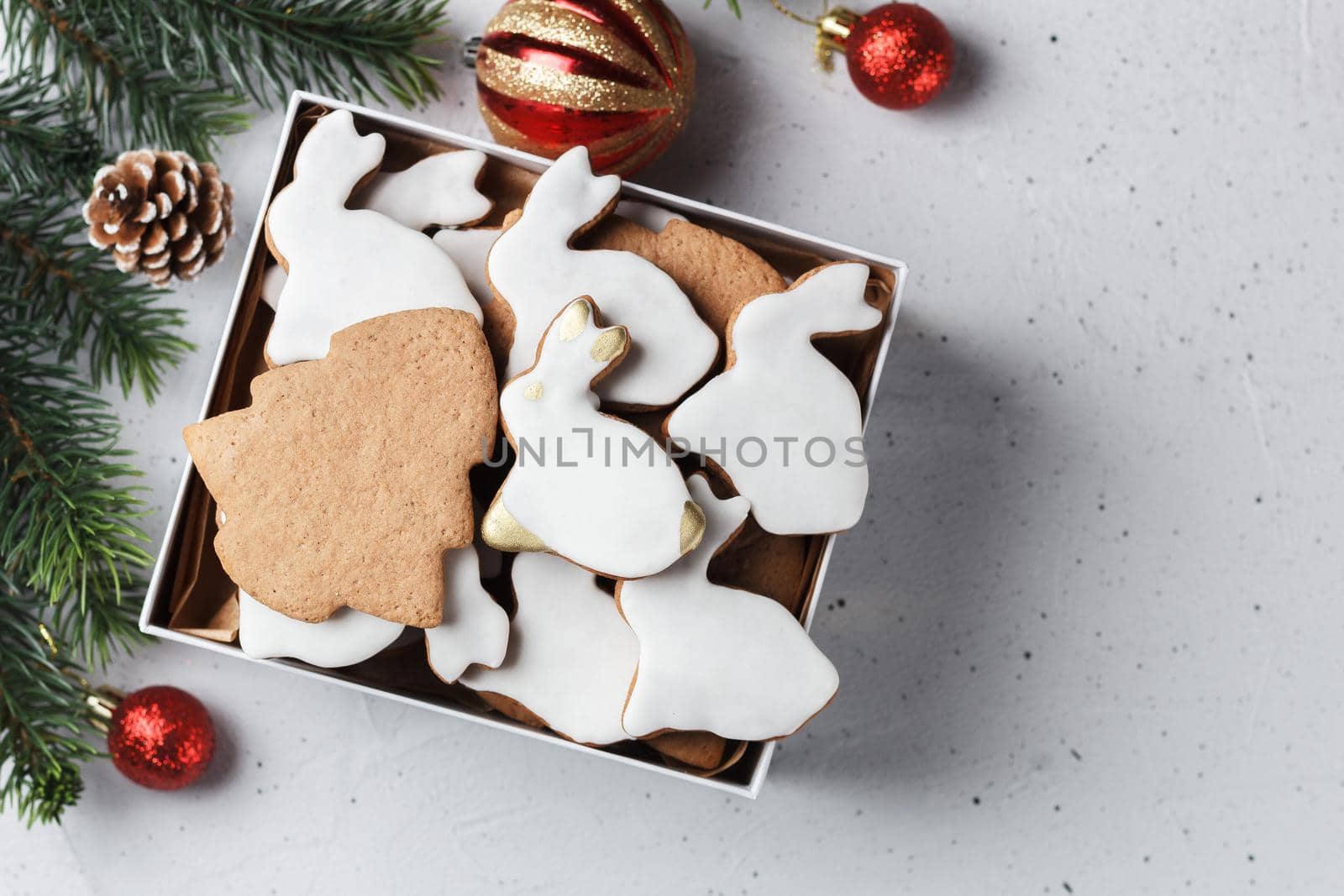 A box of Christmas cookies in the form of a rabbit and a Christmas tree on the table with New Year's decor. copy space