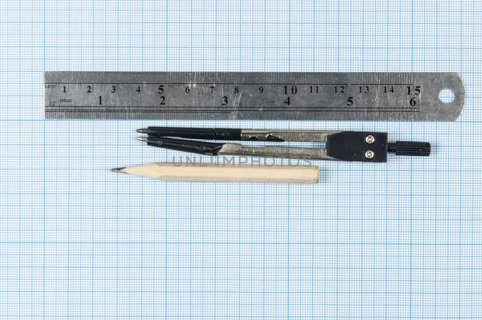 Still life photo of engineering graph paper with pencil, compasses and metal ruler blank to add your own design