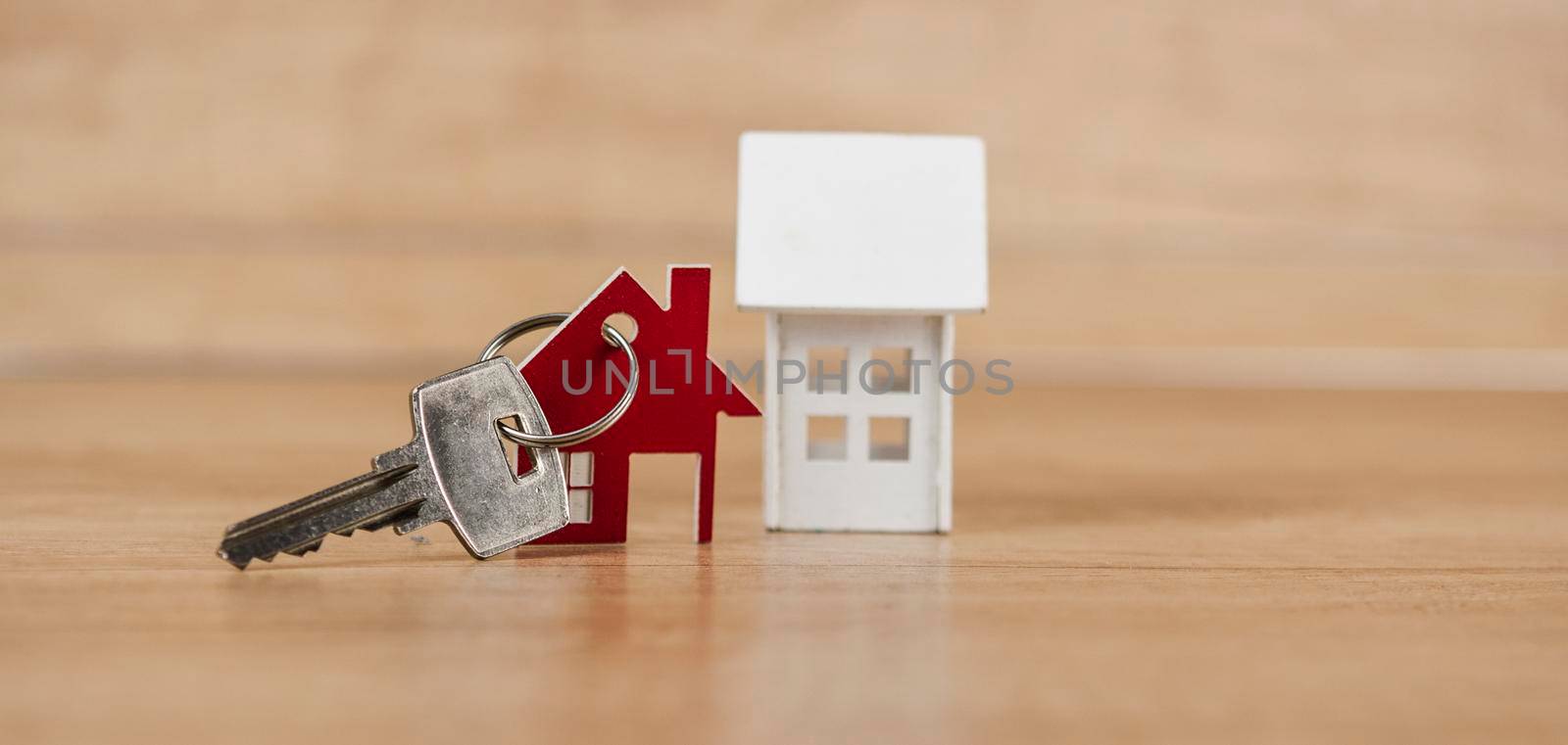 House symbol with metal key on wood table. Real estate, insurance concept, mortgage, buy sell house, realtor concept 