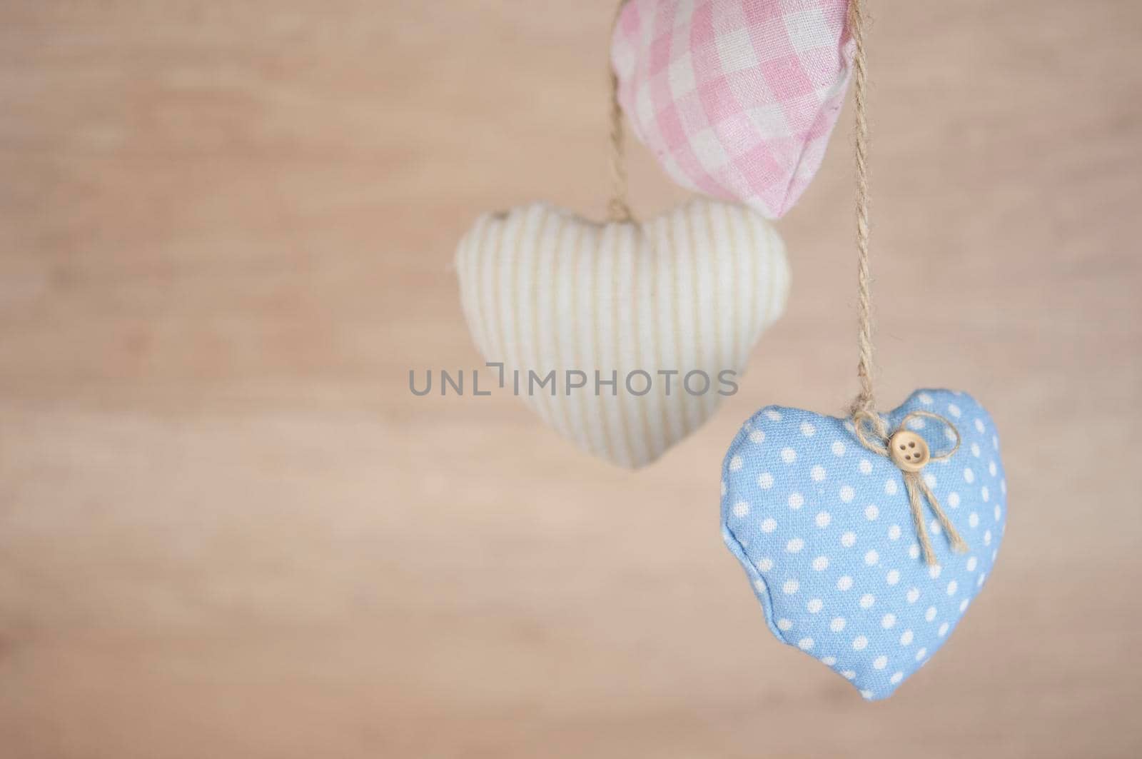 Fabric colorful hearts hanging on brown wooden wall. Happy Valentines Day