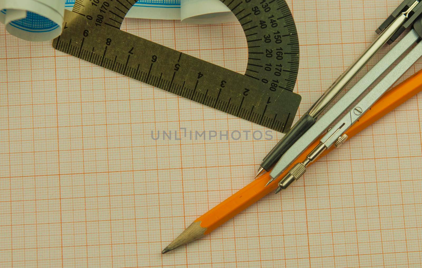 Mathematical instruments lie on a graph paper with copy space for text. Math graphic tools concept.