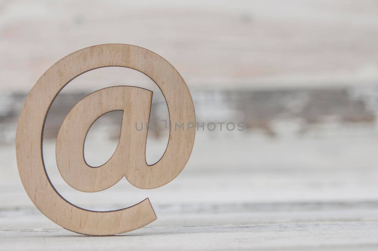 An email sign on a old white wood lies on a vintage wooden table. Concept e-mail message letter. Top view with copy space