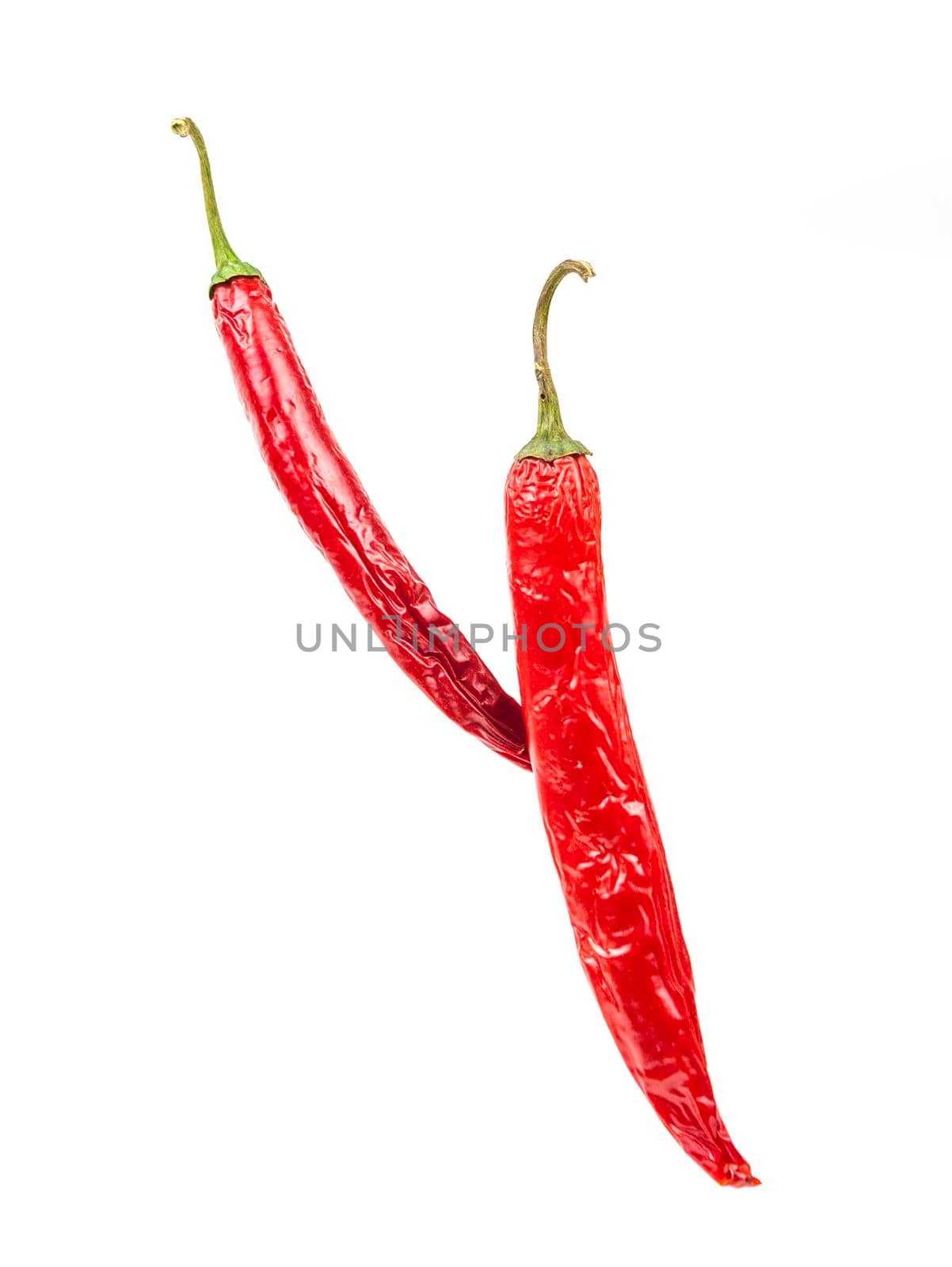 Falling red chili or chilli pepper on white background