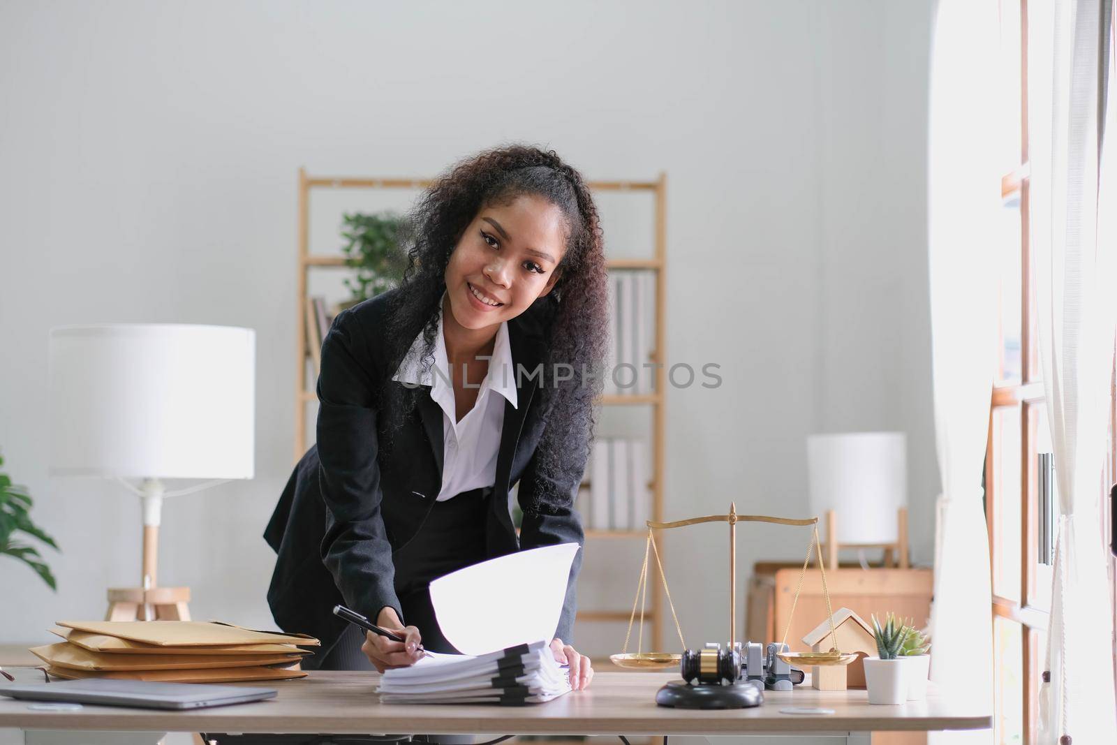 Portrait of young female Lawyer or attorney working in the office, smiling and looking at camera. by wichayada