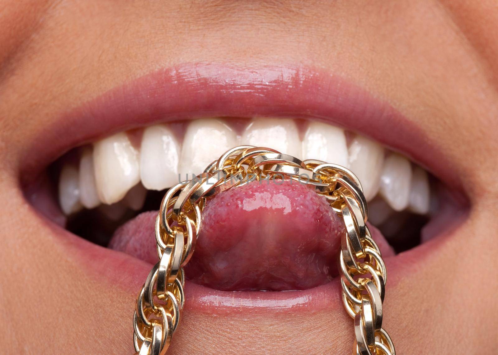 Beauty sexy woman lips smile and gold chain on tongue close-up shot