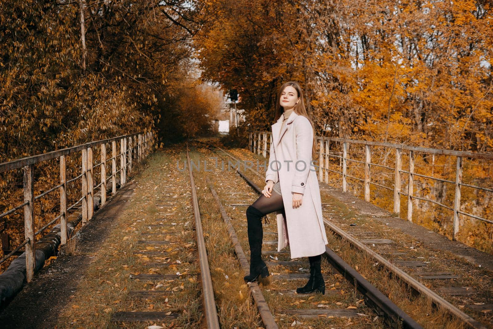 beautiful long-haired woman walks through the autumn streets. Railway, autumn, woman in a coat. by Annu1tochka