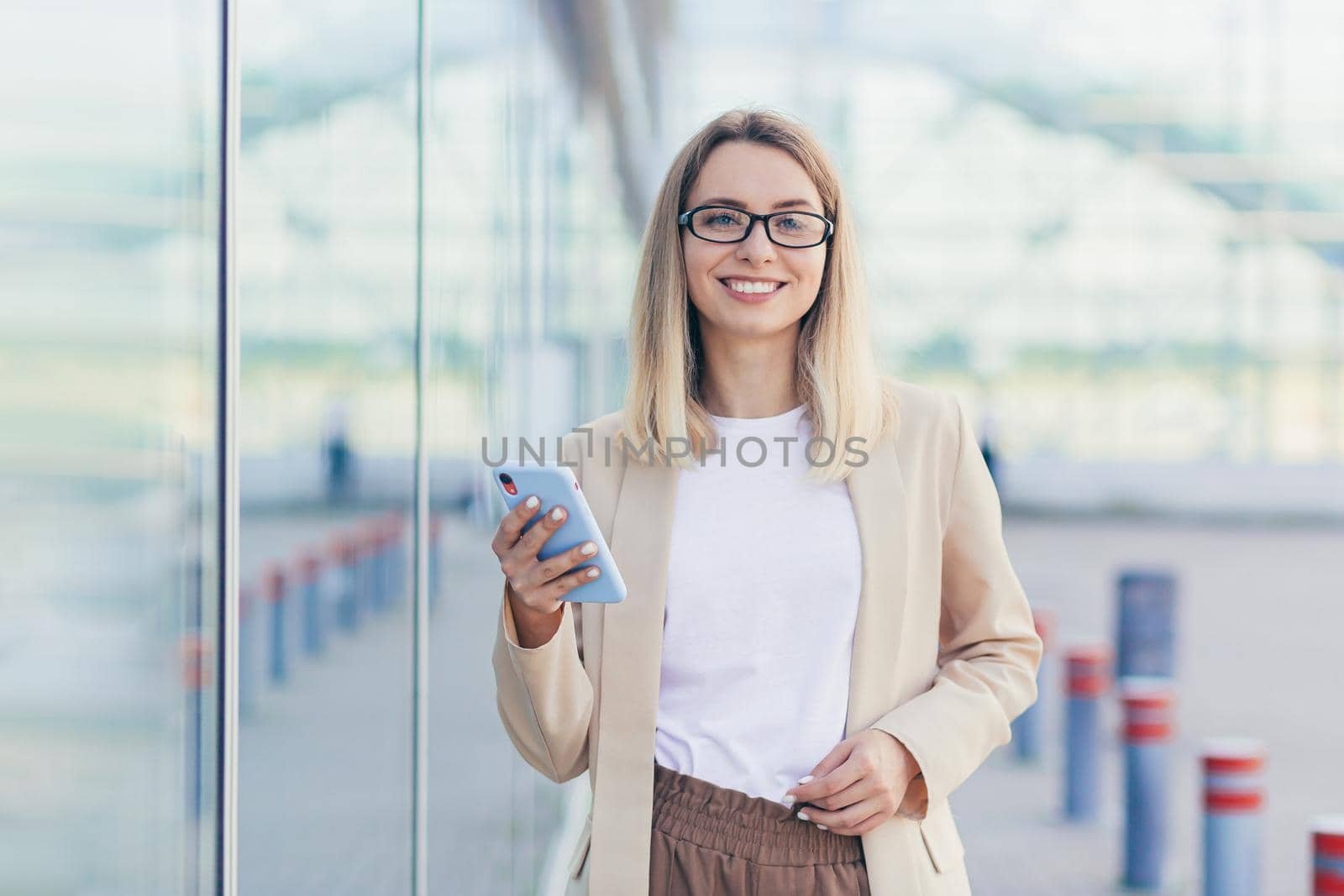 Beautiful woman holding a phone in her hands looking into the camera