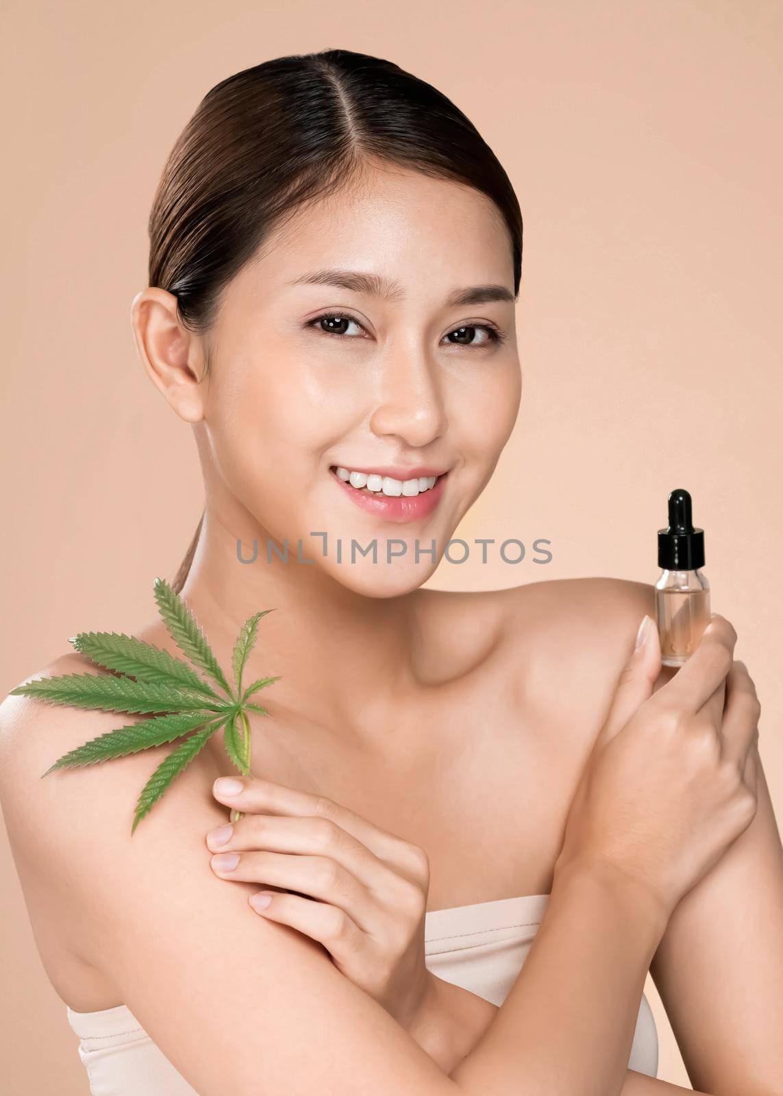 Closeup young ardent woman with healthy skin holding hemp leaf and cbd oil. by biancoblue