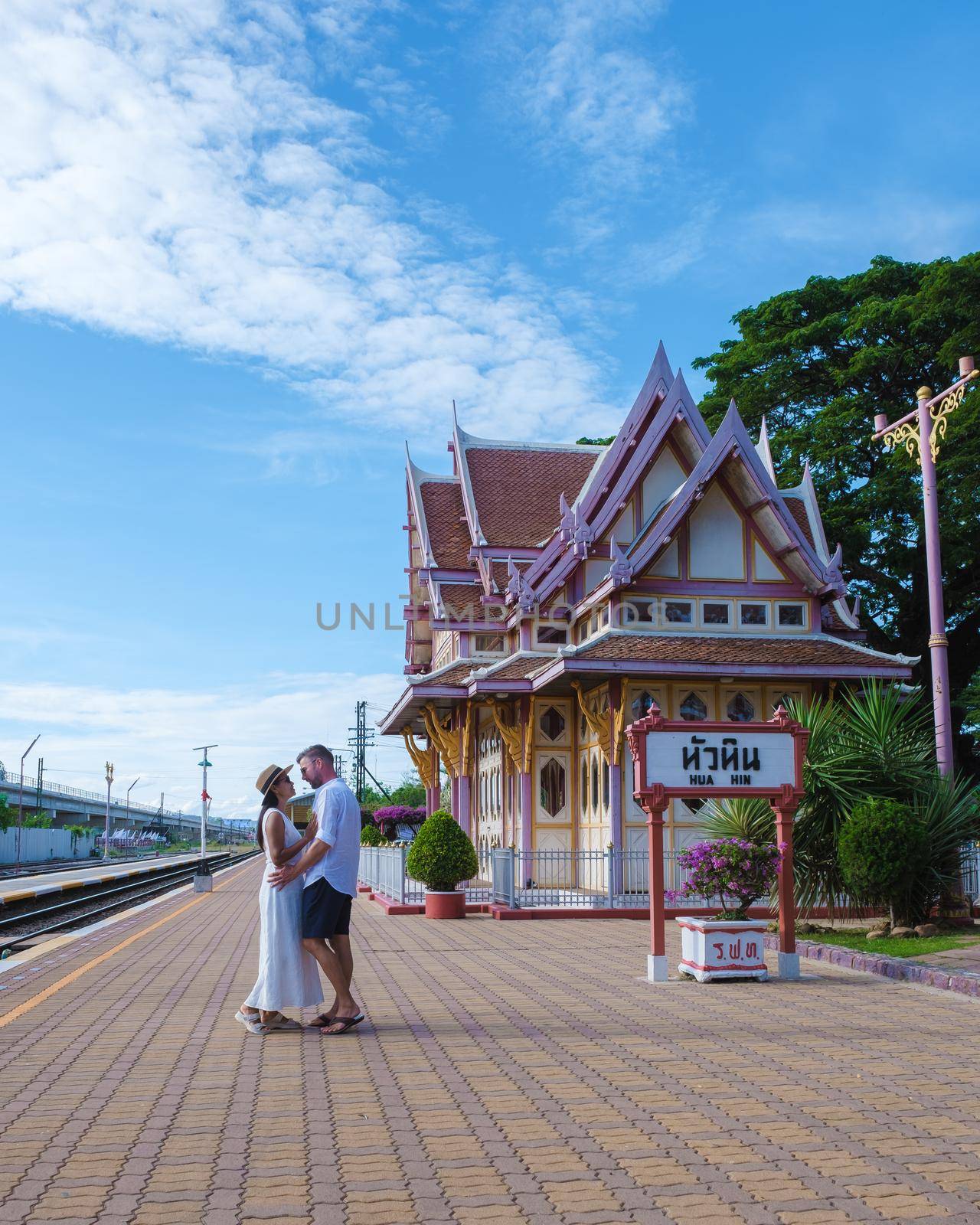 A couple of men and women are walking at Hua Hin train station in Thailand. Asian women and Caucasian men walking at the train station of Huahin