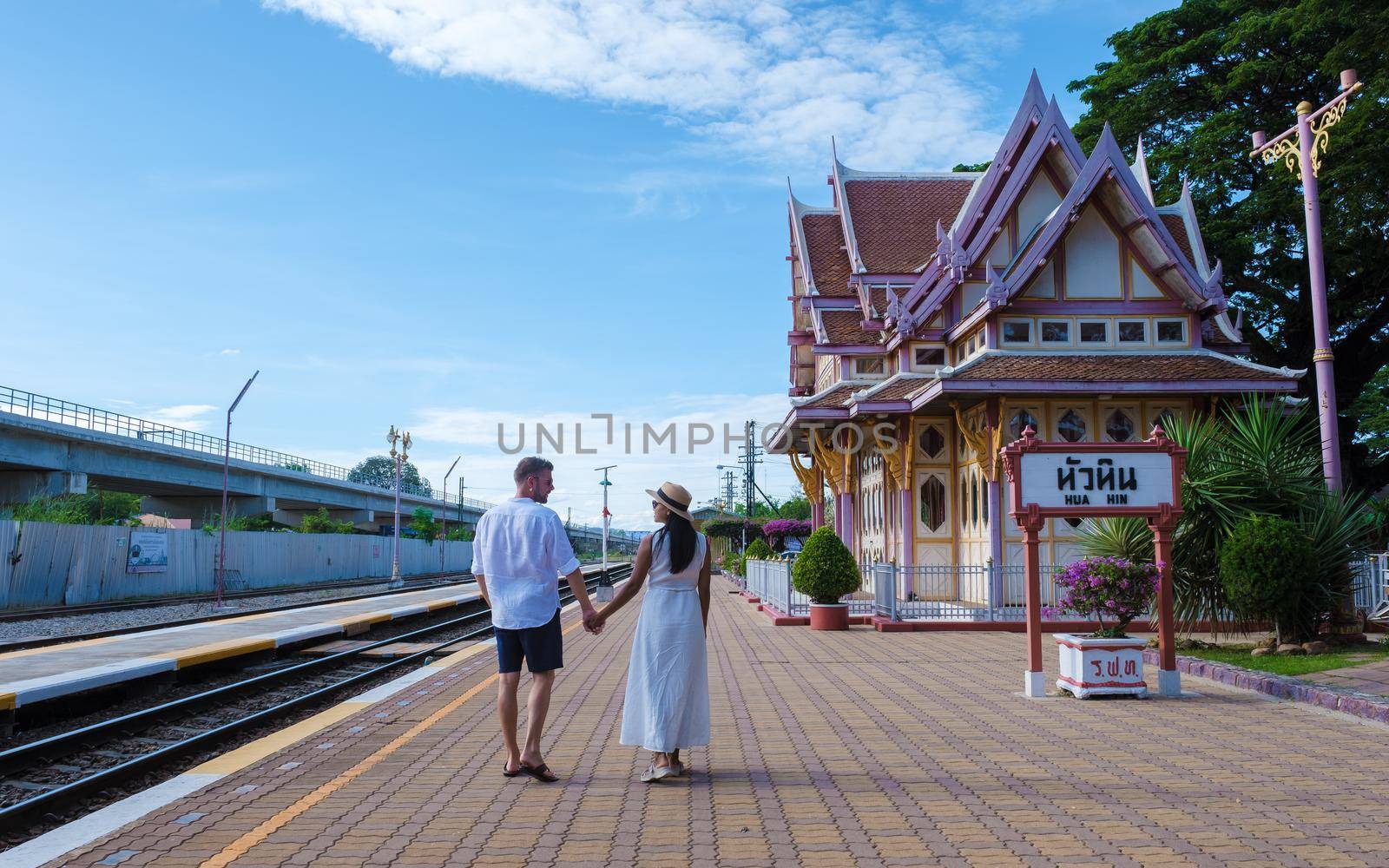 Hua Hin train station in Thailand on a bright day, men and women walking at train station Huahin by fokkebok