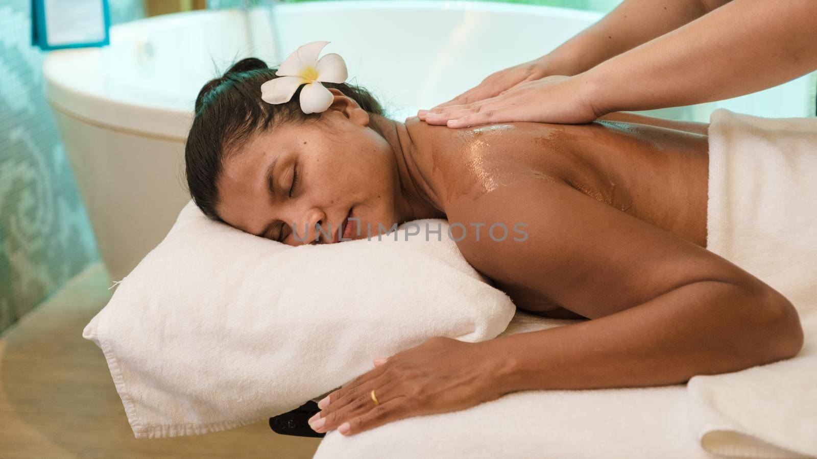Asian women on a massage table, Asian woman getting a Thai massage at a luxury hotel in Thailand by fokkebok