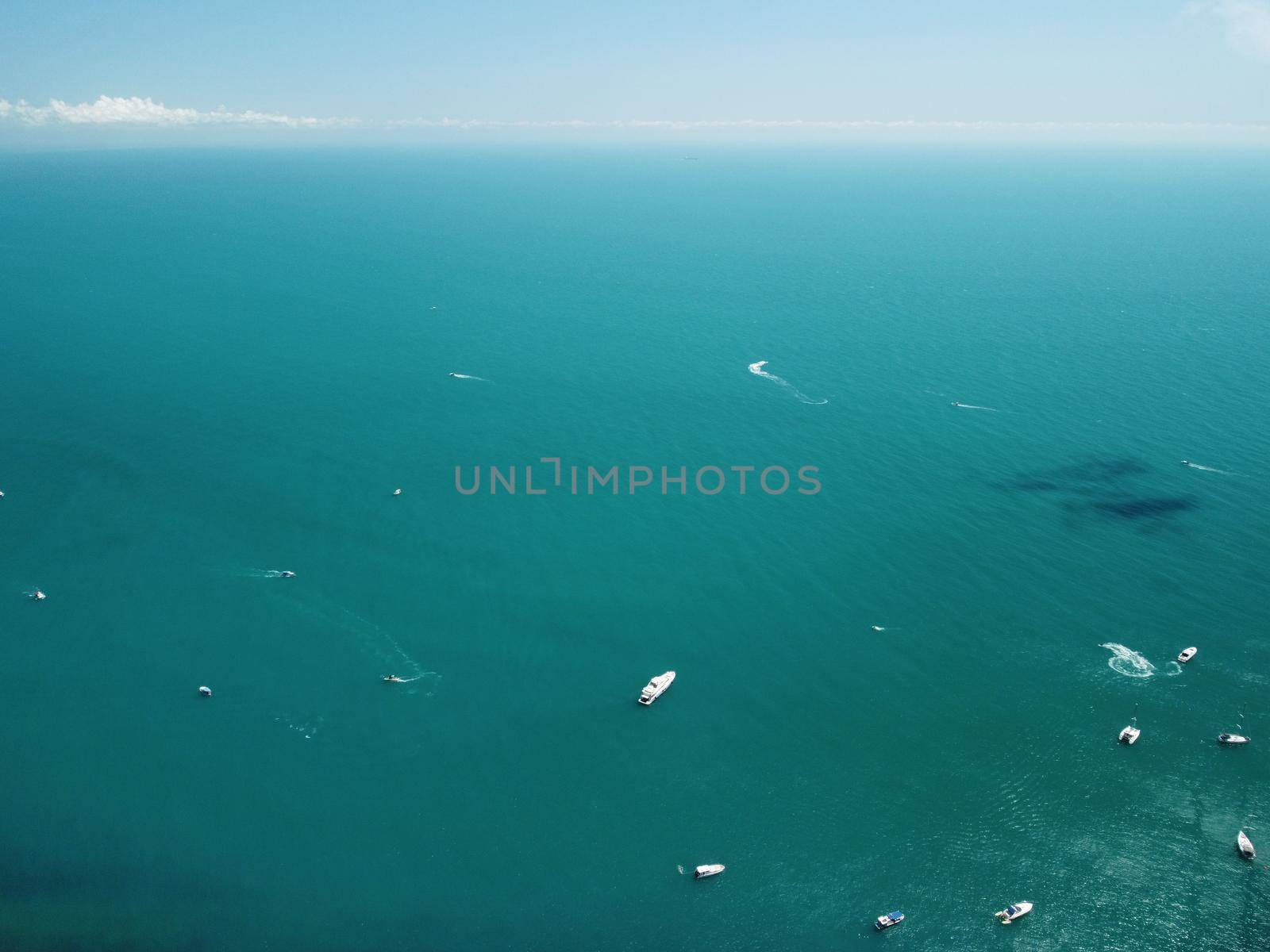 Aerial boat race. Luxury cruise trip. View from above of white boat on deep blue water. Aerial view of rich yacht sailing sea. Motor boat racing wave. Summer journey on luxury ship