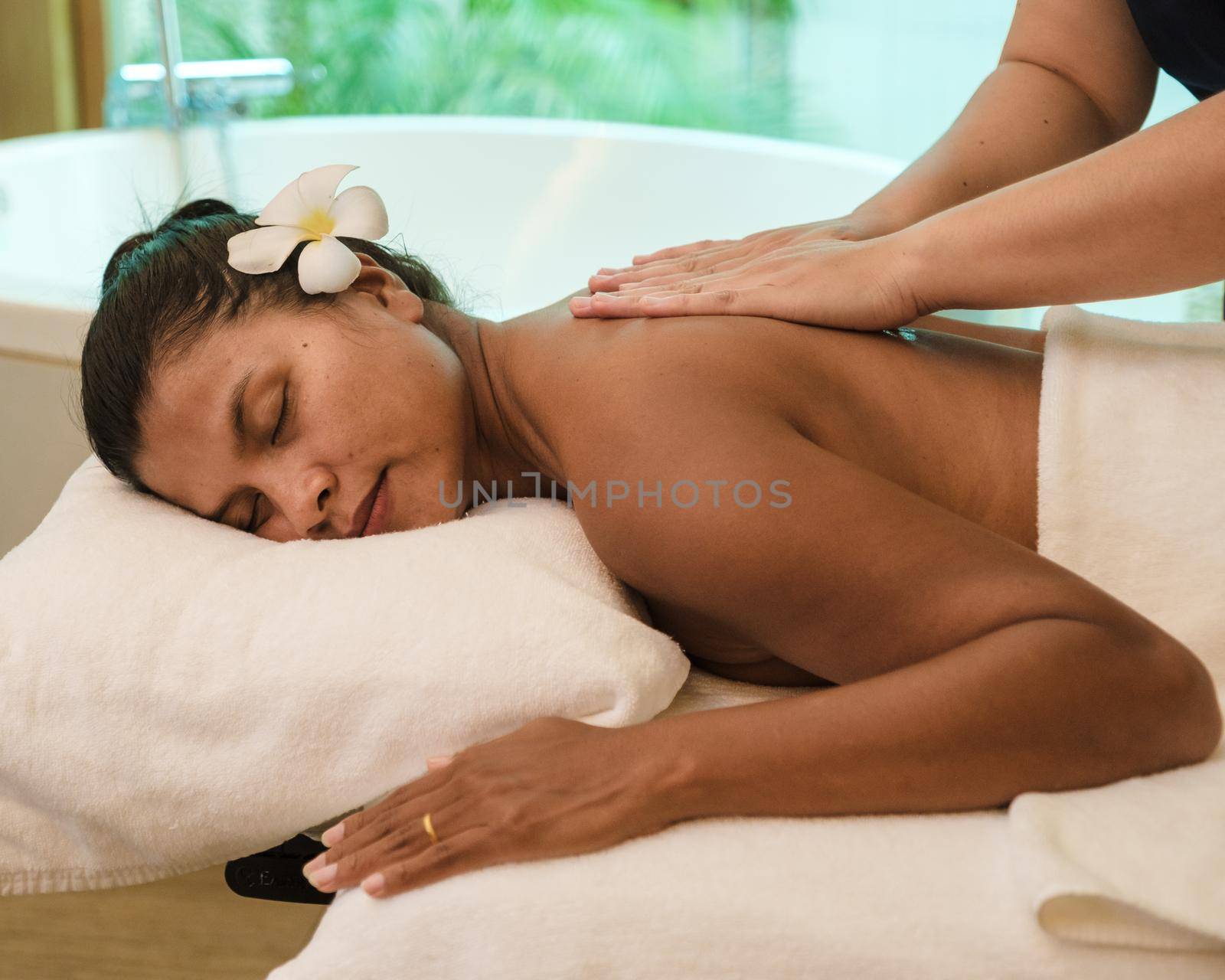 Asian women on a massage table, Asian woman getting a Thai massage at a luxury hotel in Thailand by fokkebok