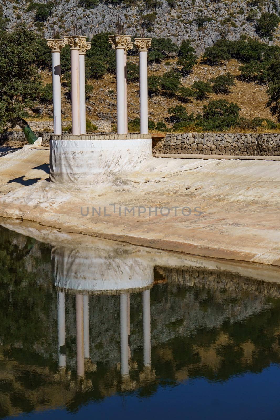 set of columns reflected in a lake in the mountain by joseantona