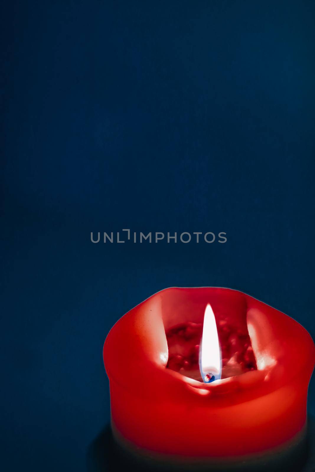 Happy holidays, greeting card backdrop and winter season concept - Red holiday candle on blue background, luxury branding design and decoration for Christmas, New Years Eve and Valentines Day