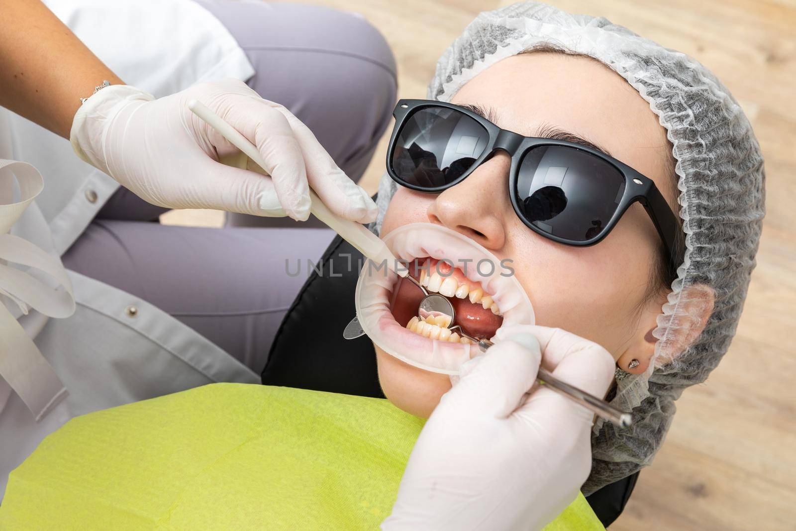 Dentist Examining Patient's Mouth with dental mirror In Clinic. Checkup concept